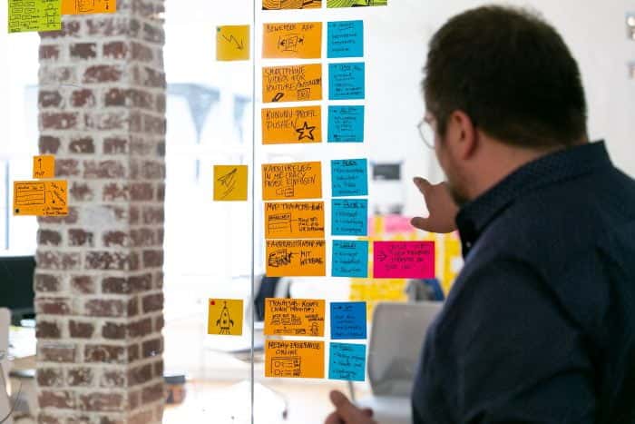 Mitarbeiter von Me & Company bespricht das Systemwechsel Programm anhand von Post-its