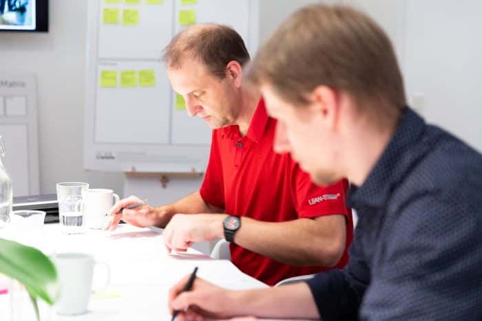 Mitarbeiter von Me & Company arbeitet gemeinsam mit einem Kunden einen Entwurf im Rahmen des Digitalwerk Programm aus
