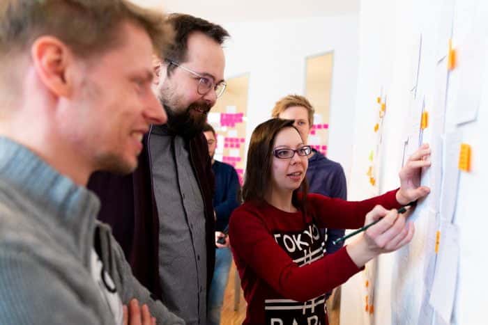 MItarbeiter von Me & Company arbeiten co-kreativ im Teamgeist Programm zusammen