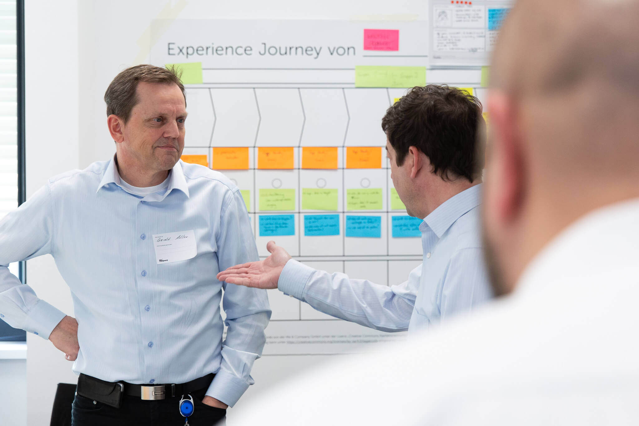 Zwei Workshop-Teilnehmer unterhalten sich vor dem Experience Journey Canvas