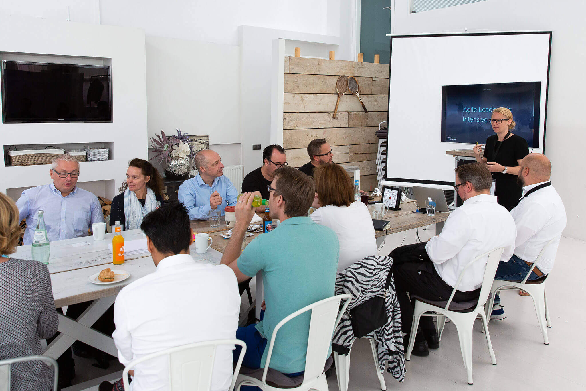 Ein Agile Coach steht vor einer Gruppe von Trainingsteilnehmern und hält einen Vortrag über Agile Leadership